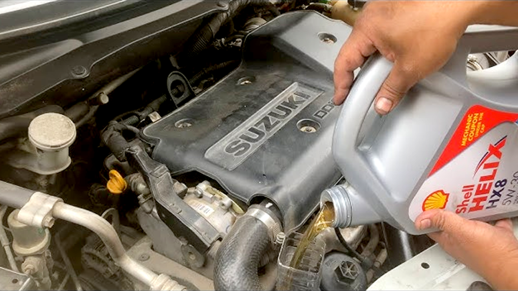 An open Maruti Swift bonnet showing a mechanic checking the engine oil level using a dipstick, in a clean workshop setting with tools in the background. Focus on the dipstick and engine bay labeled for clarity.